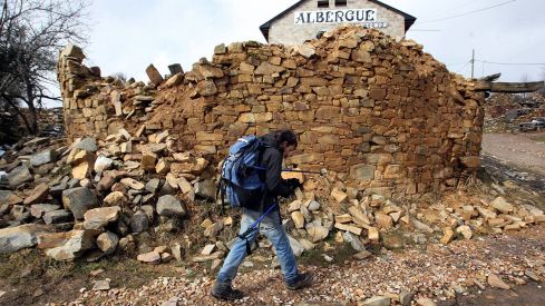 Peregrino haciendo el Camino de Santiago a su paso por la Cruz do ferro