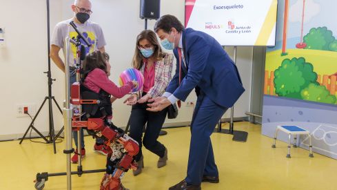 Alfonso Fernández Mañueco junto a la primera paciente que ha probado el exoesqueleto y sus padres