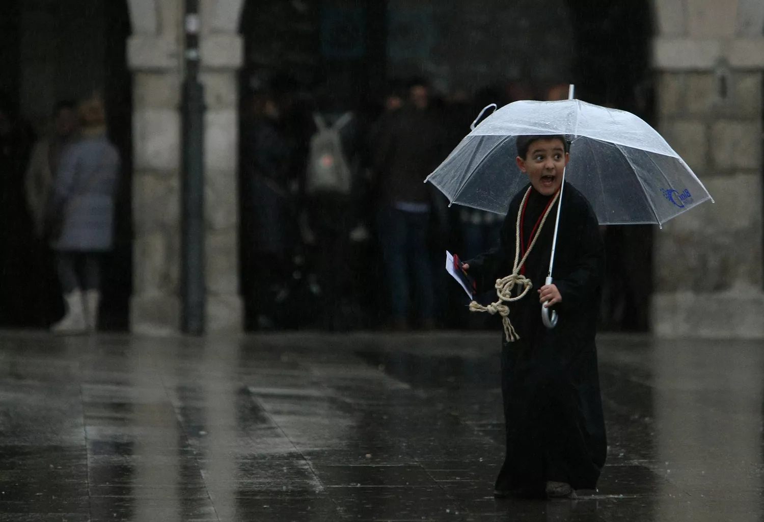 César Sánchez, ICAL . Un niño nazareno se protege de la lluvia con un paragüas al finalizar la procesión infantil de Ponferrada en Semana Santa