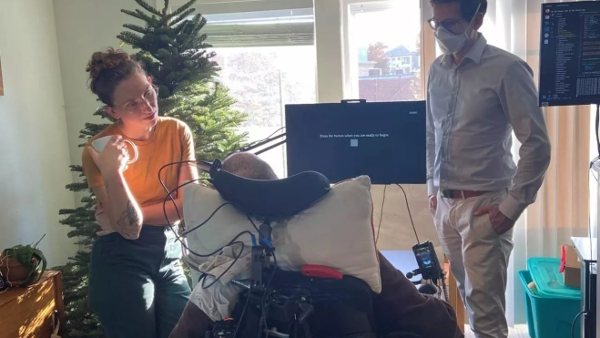 El participante Casey Harrell con su asistente personal Emma Alaimo y el neurocientífico de la UC Davis Sergey Stavisky El participante Casey Harrell con su asistente personal Emma Alaimo y el neurocientífico de la UC Davis Sergey Stavisky