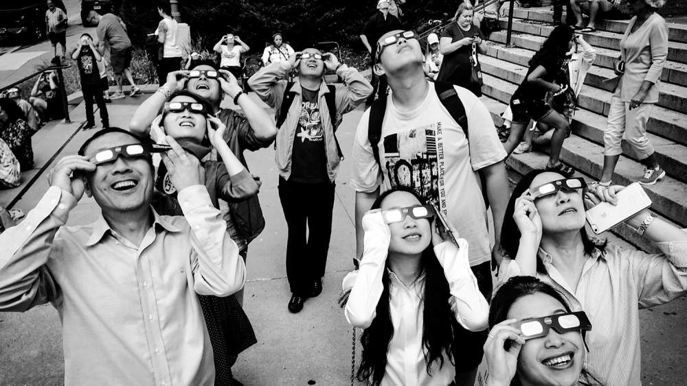 Gente mirando un eclipse con gafas especiales (Pixabay)