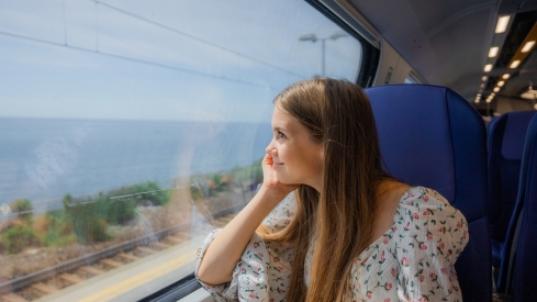 Imagen de una usuaria viajando en un tren playero 
