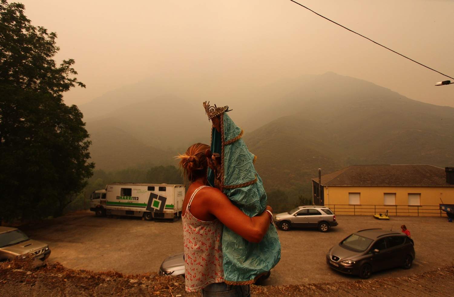 César Hornija / ICAL. Una vecina de Lusio (Oencia), rescata la Santa del pueblo ante la posible llegada del fuego