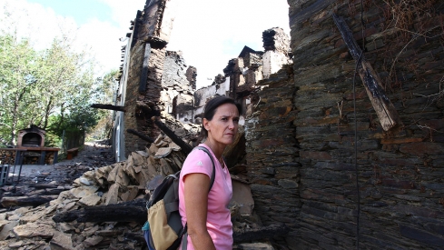 César Hornija- Silvia Vergara, vecina de Lusio, junto a su casa arrasada por el fuego