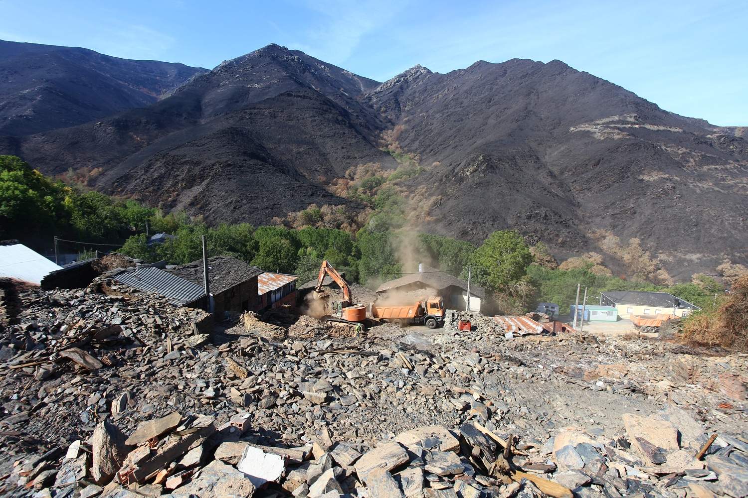 César Hornija / ICAL . Trabajos de derribo y desescombro de las casas afectadas por el incendio en la localidad de Lusio (León)