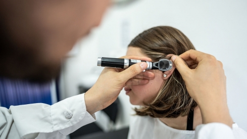 Médico otorrinolaringólogo usando un otoscopio en el oído de un paciente en una clínica médica. iStock Frazao Studio Latino