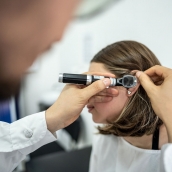 Médico otorrinolaringólogo usando un otoscopio en el oído de un paciente en una clínica médica. iStock Frazao Studio Latino