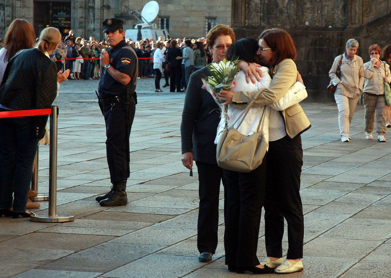 Pepe Ferrín AGN ICAL. Una persona del público se acerca a un familiar de las víctimas para darle un ramo de flores en el funeral oficial por las 79 víctimas mortales del accidente ferroviario