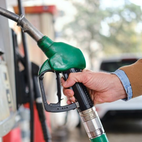Un hombre repostando en una gasolinera | IStock - Lemon Photo