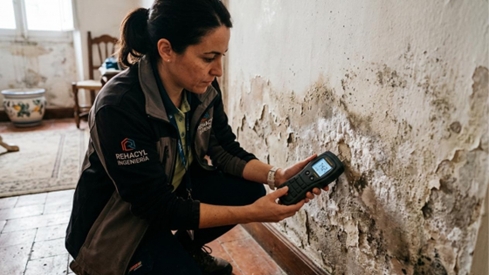Técnico especialista midiendo el nivel de humedad en la base de un muro con higrómetro de contacto, paso previo al diagnóstico diferencial. Técnico especialista midiendo el nivel de humedad en la base de un muro con higrómetro de contacto, paso previo al diagnóstico diferencial.