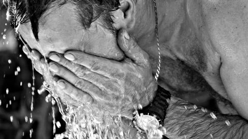 Un hombre se refresca del calor Canva