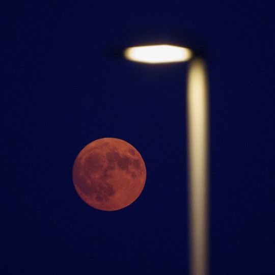 César Sánchez / ICAL. Luna llena teñida de rojo por la calima y el humo de los incendios vista desde El Bierzo