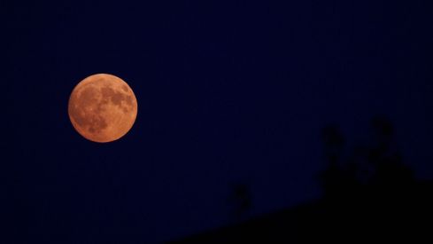 César Sánchez / ICAL. Luna llena teñida de rojo por la calima y el humo de los incendios vista desde El Bierzo