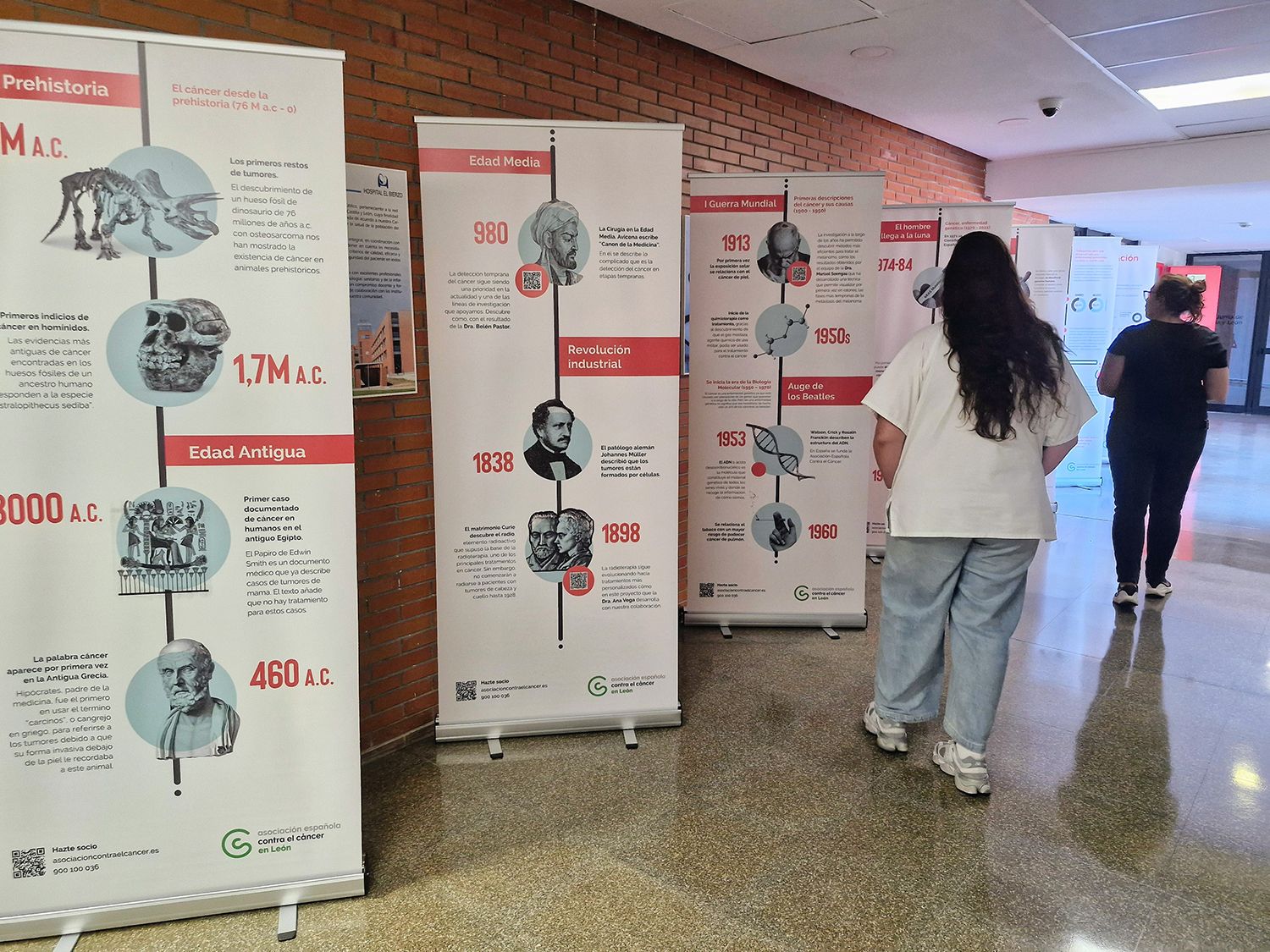 Dos personas observan la exposición de la Asociación Española Contra el Cáncer en el Hospital El Bierzo Dos personas observan la exposición de la Asociación Española Contra el Cáncer en el Hospital El Bierzo